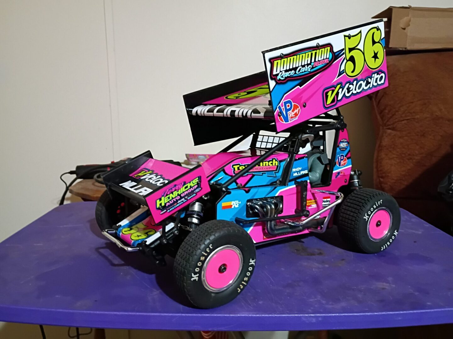 Colorful remote-controlled off-road buggy with vibrant decals and large rear wing.